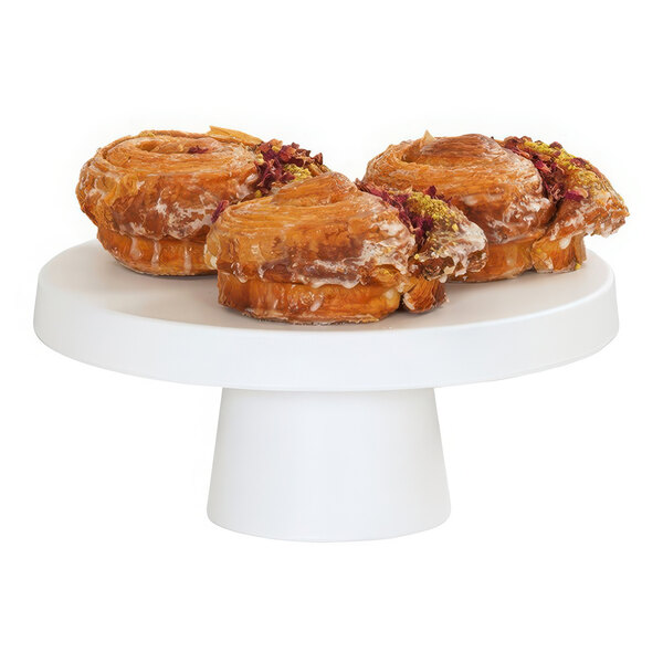 A group of pastries on a white Cal-Mil cake pedestal.