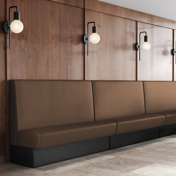 A long brown upholstered single back booth with a 36-inch high backrest, set against a wood-paneled wall.
