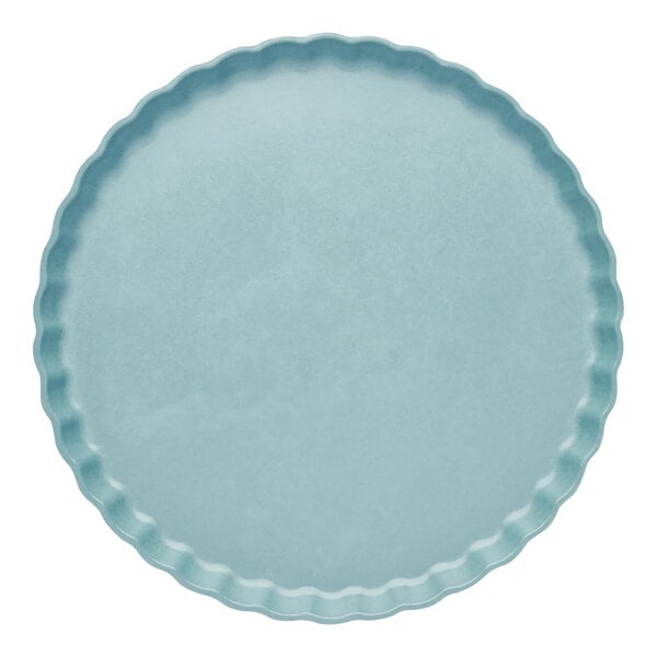 A blue round Sophistiplate Simply Eco pool plant fiber dinner plate with a scalloped edge.