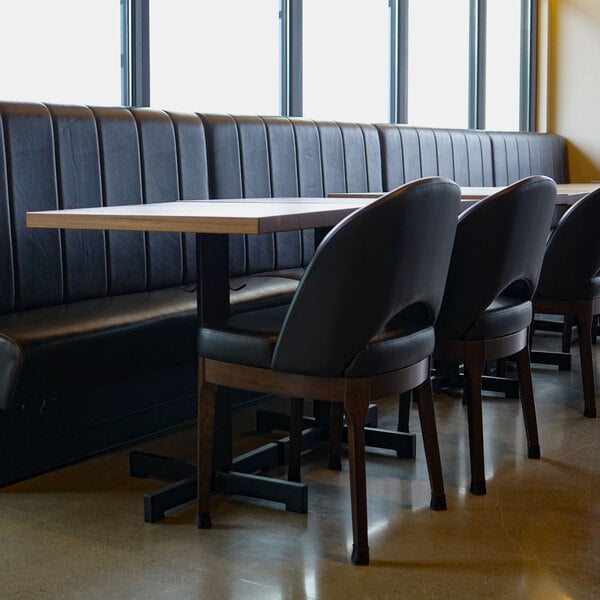 A 60-inch long, 42-inch high ebony channel single back booth with a modern design, placed alongside a dining table and chairs.