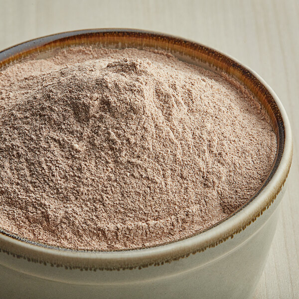 A bowl filled with light brown cinnamon sugar popcorn seasoning powder.