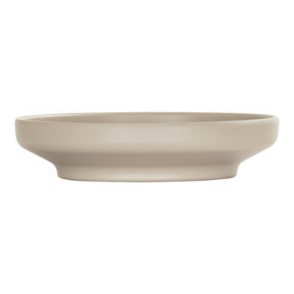 A taupe round coupe melamine bowl/plate with a plain white surface.