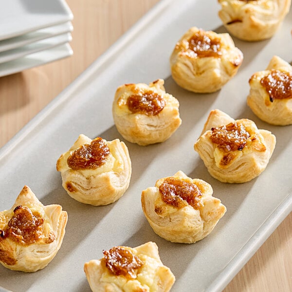 A tray of Simply Cuisine Caramelized Onion and Feta Cheese Tarts on a table.
