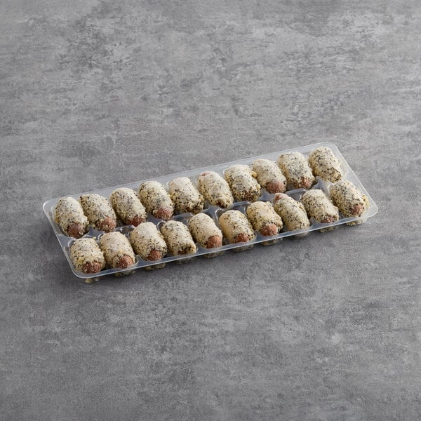 A plastic tray of Cuisine Innovations Everything Franks in Puff Pastry with a lid.