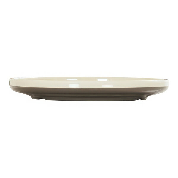 A white Cal-Mil melamine plate with a brown rim.