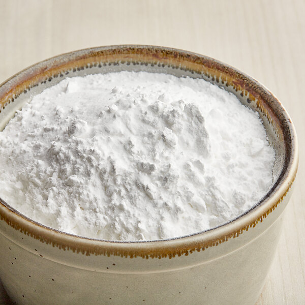 A bowl filled with fine white popcorn seasoning powder.