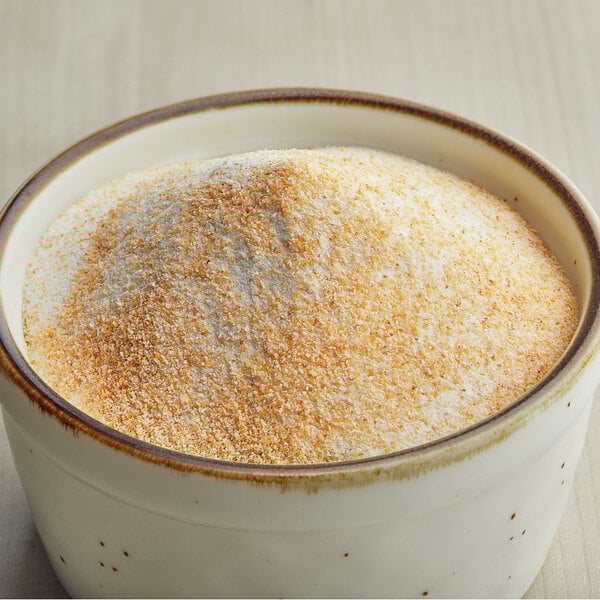 A bowl filled with finely ground savory garlic popcorn seasoning.