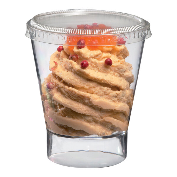 A close-up of a dessert in a clear Solia plastic cup with cranberries.