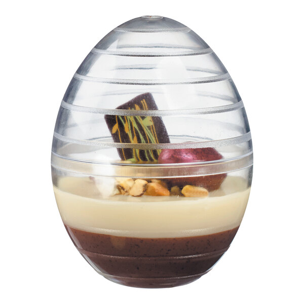 A Solia clear plastic mini bowl in the shape of an egg with a dome lid containing a chocolate dessert.