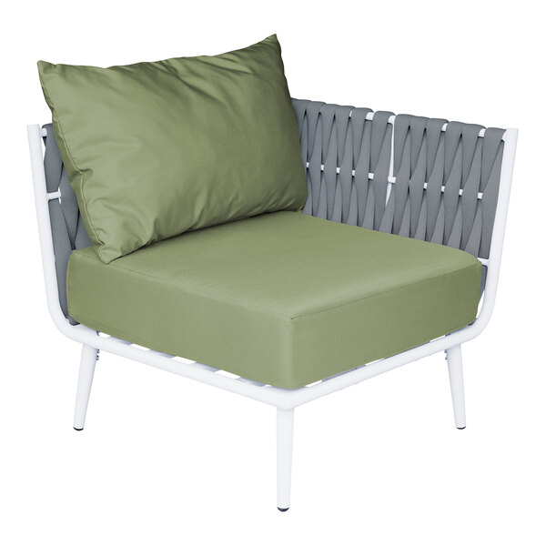 A white outdoor BFM Seating Cayman corner chair with a green Sunbrella cushion and pillow.