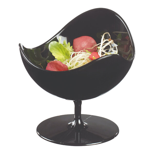 A Solia black plastic ball chair cup filled with salad on a table in a salad bar.