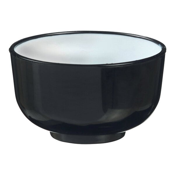 A black Solia Thai bowl with white rim.