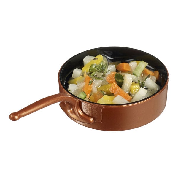 A Solia Eskoffie mini plastic frying pan with vegetables in it.