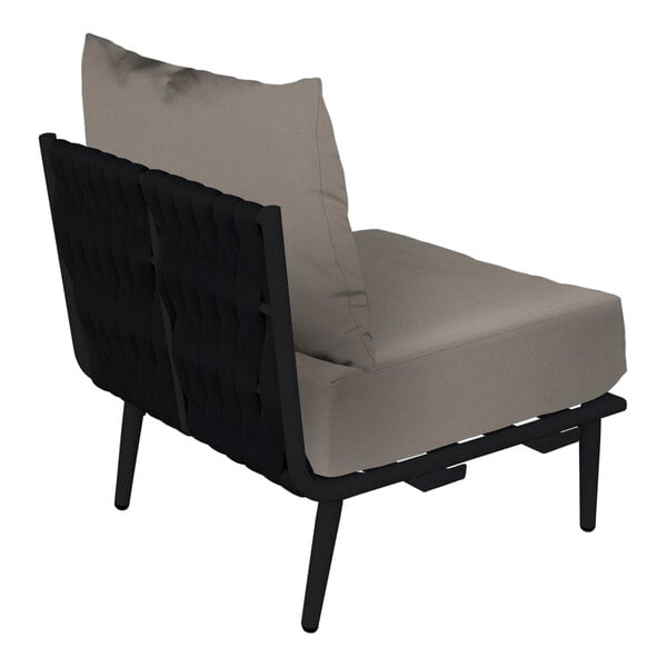 A BFM Seating Cayman black outdoor middle section chair with Sunbrella charcoal cushion and back pillow.