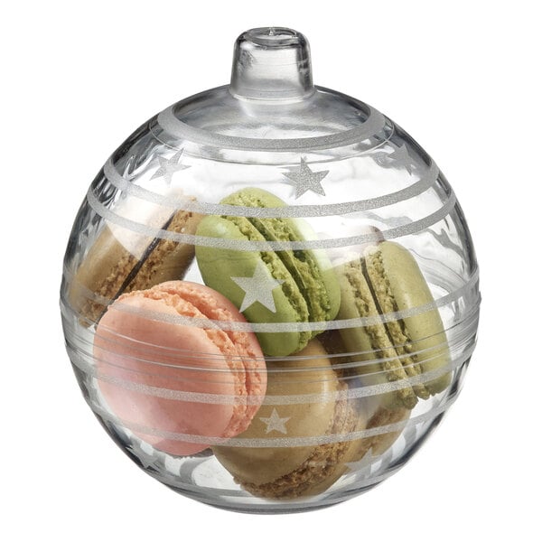 A clear plastic bauble bowl filled with green and pink macaroons.