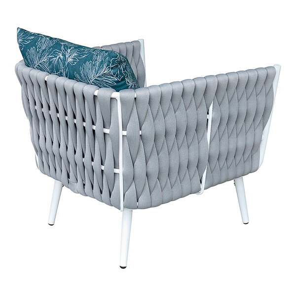 A white wicker armchair with blue cushion and pillow on it.