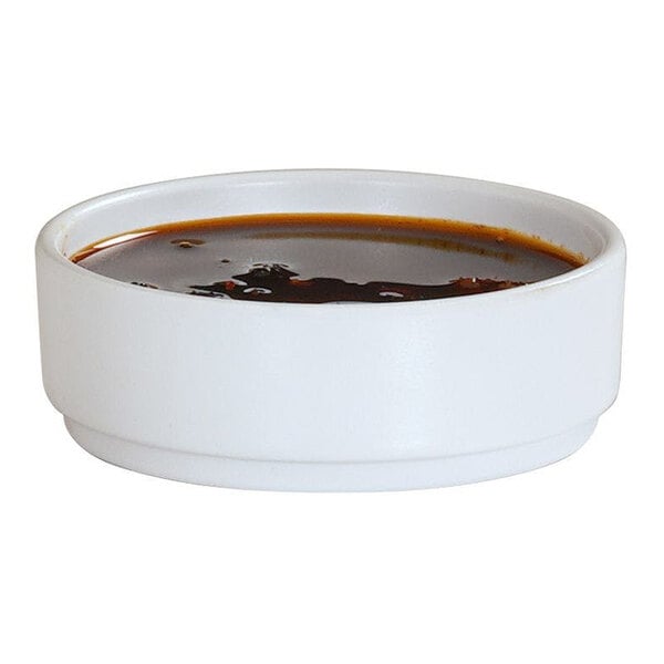 A small white straight-sided melamine ramekin filled with a dark liquid.