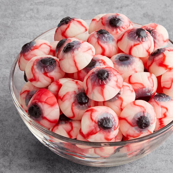A glass bowl filled with gummy candies shaped like bloodshot eyeballs.