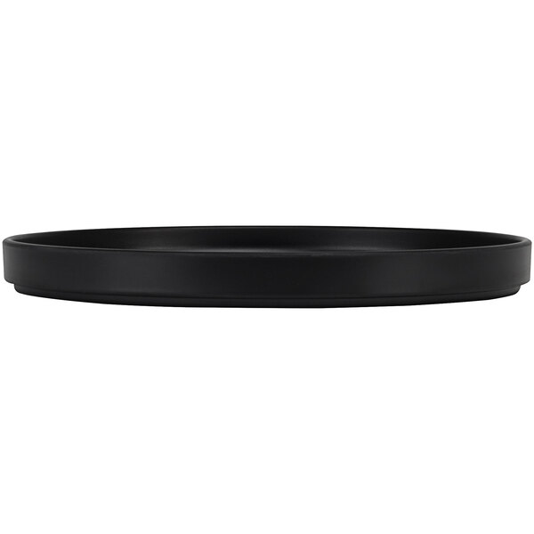 A black round Cal-Mil melamine plate on a table.