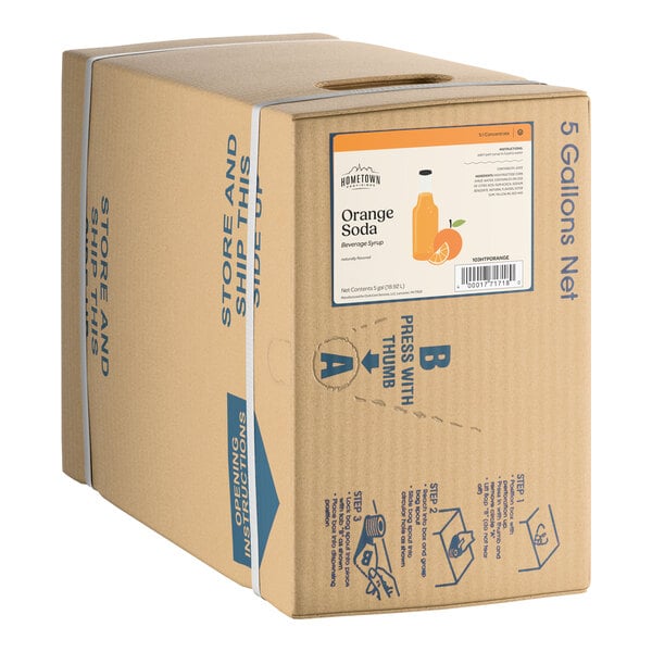 A 5-gallon bag-in-box container of Hometown Provisions Orange Soda beverage syrup.