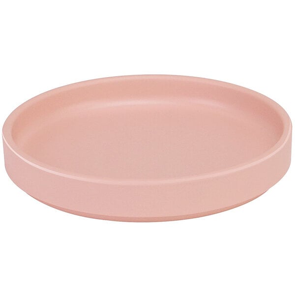 A pink round Cal-Mil melamine plate with a low rim.