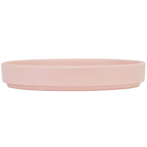 A close-up of a Cal-Mil blush low rim melamine plate with a flat bottom in pink.
