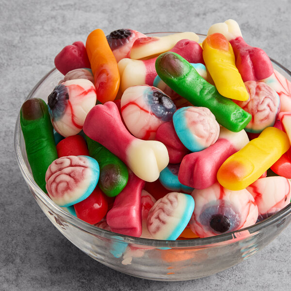 A glass bowl filled with assorted Vidal gummy candies shaped like body parts such as eyeballs, fingers, and brains.