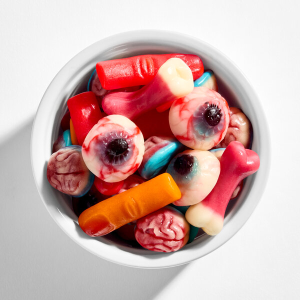A bowl filled with colorful gummy candies shaped like eyeballs, brains, bones, and fingers.