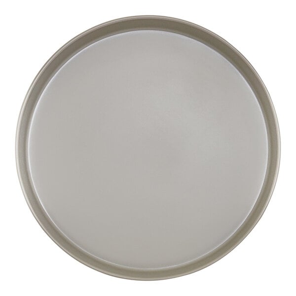 A close-up of a white Cal-Mil melamine plate with a raised rim and a circle.