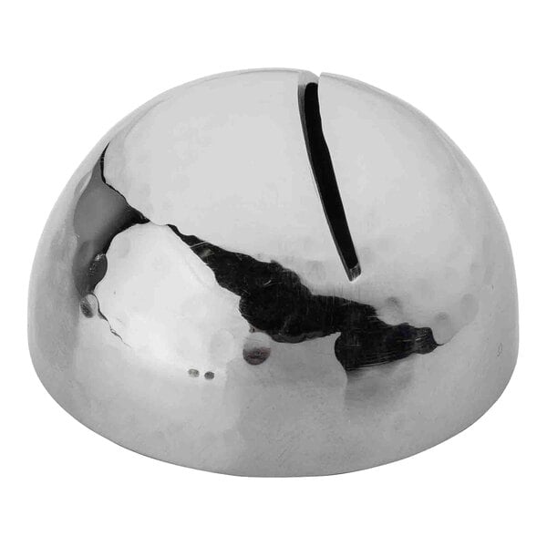 A round stainless steel object with a hammered design and a crack in the middle.