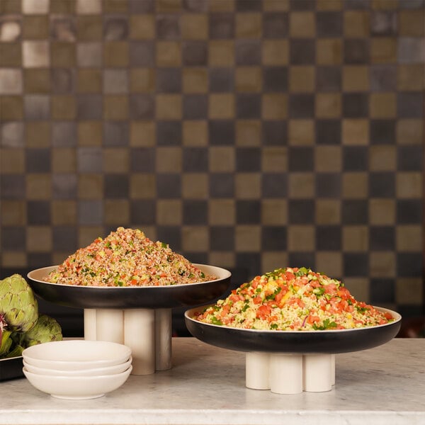 A table with ivory and black Cal-Mil Sophie melamine bowls of food.