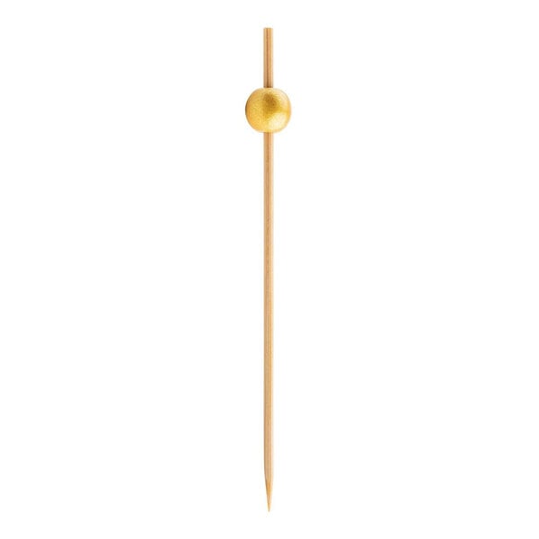 A wooden stick with a gold ball on it.