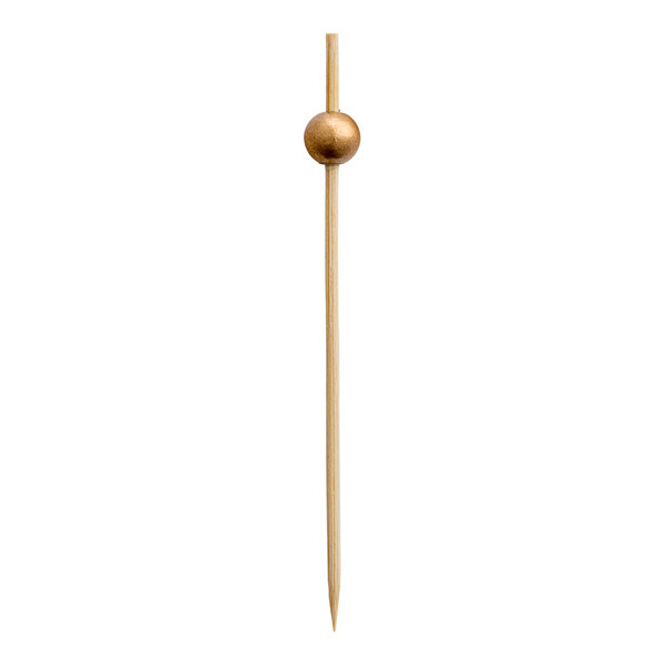 A bamboo cocktail pick with a gold ball decoration near the top.
