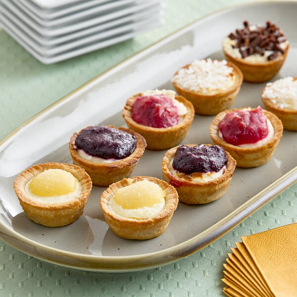 A plate of Cuisine Innovations Mini Assorted Cheesecakes on a table at a catering event.