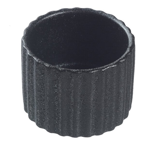 A black round fluted porcelain dish with a textured surface.