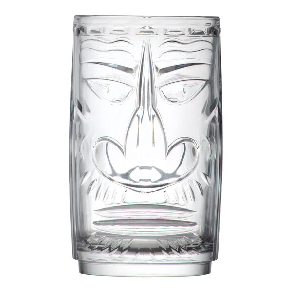 A clear glass tiki-style drinking glass with a face design.
