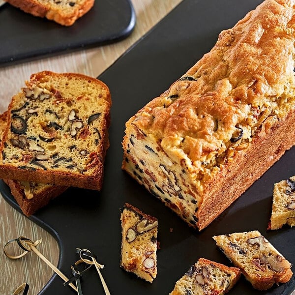 A loaf of bread with nuts in a de Buyer stainless steel loaf pan.