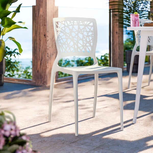 A white resin side chair with a webbed back design.
