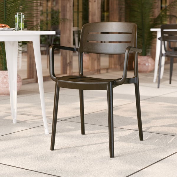A brown resin arm chair with a slat back design.