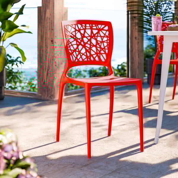 A red resin side chair with a webbed back design.