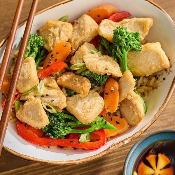 A bowl of Beyond Meat plant-based vegan unbreaded chicken pieces served with mixed vegetables and rice.
