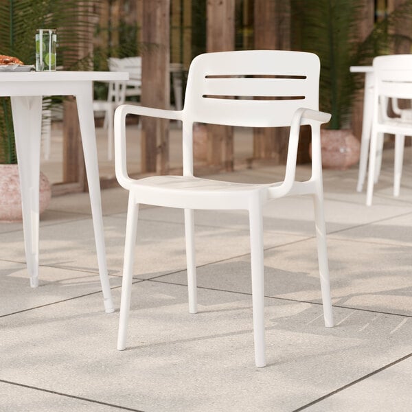 A white resin arm chair with a slat back design, suitable for outdoor or indoor seating.