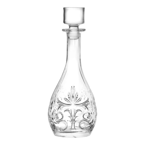A clear glass decanter with an ornate etched design and a stopper.