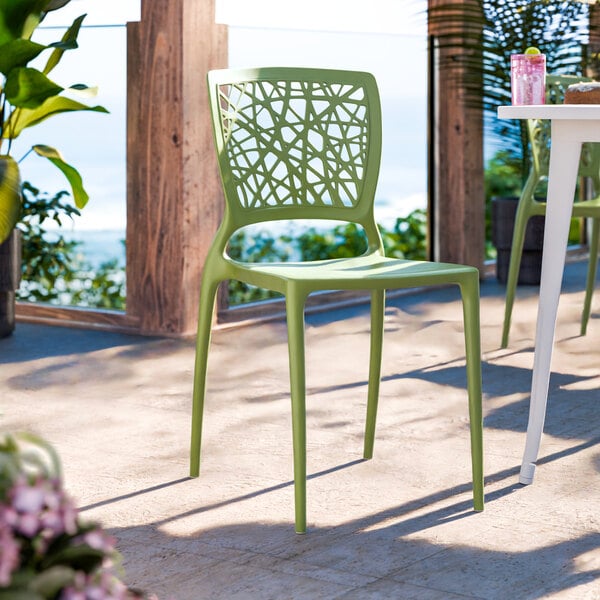 A green resin side chair with a webbed back design.