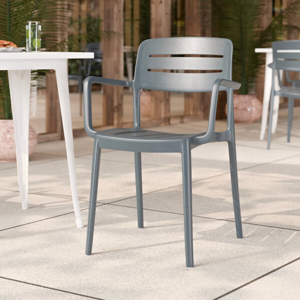 A gray resin arm chair with a slat back design, suitable for outdoor use.