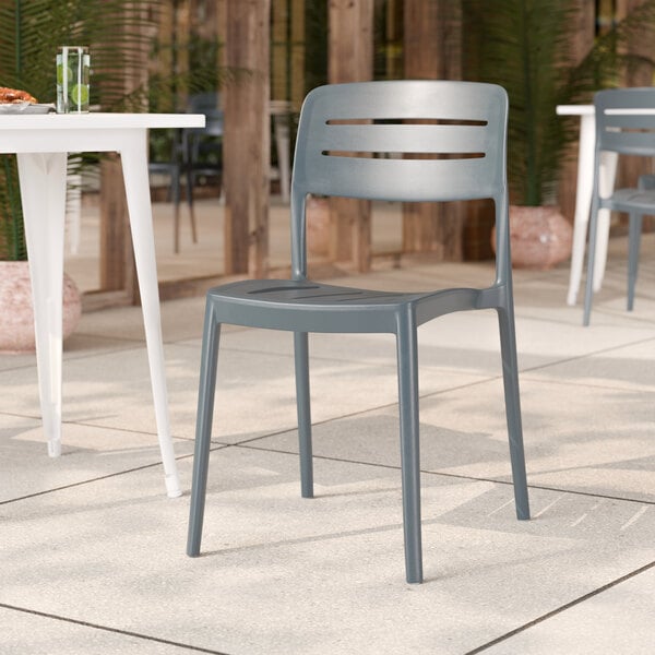 A gray resin side chair with a slat back design, suitable for outdoor or indoor use.