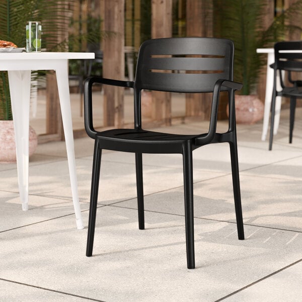 A black resin arm chair with a slat back design.