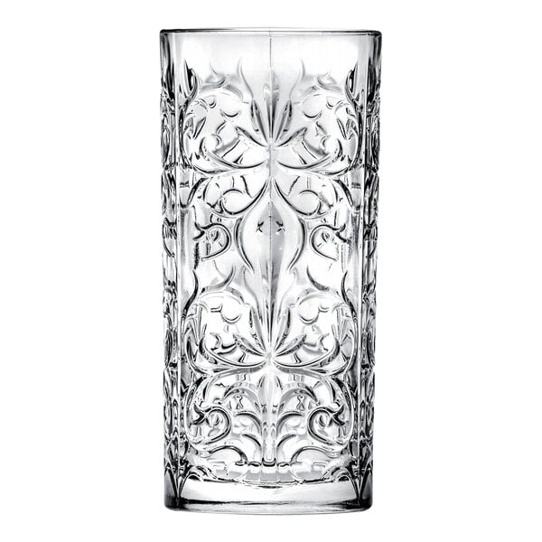 A clear highball glass with an ornate, embossed pattern.