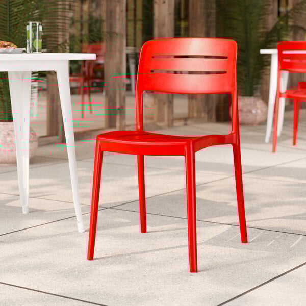 A red resin side chair with a slat back design.