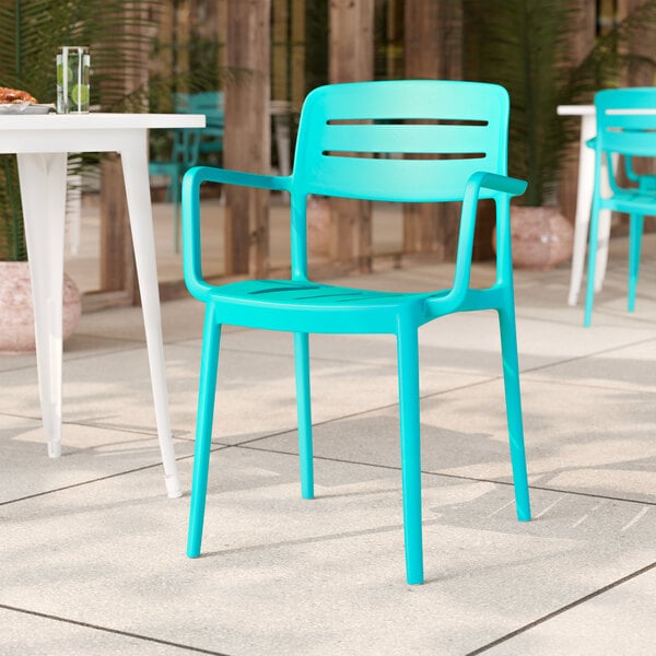 A coastal blue resin arm chair with a slat back design.